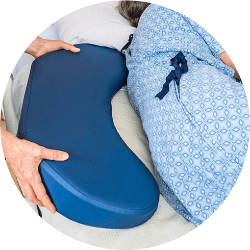 Bedsore Rescue pressure-relieving cushion being placed under patient